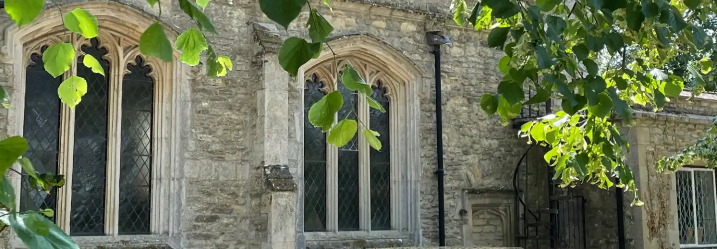 St James's Church side view through the overhanging leaves of a tree