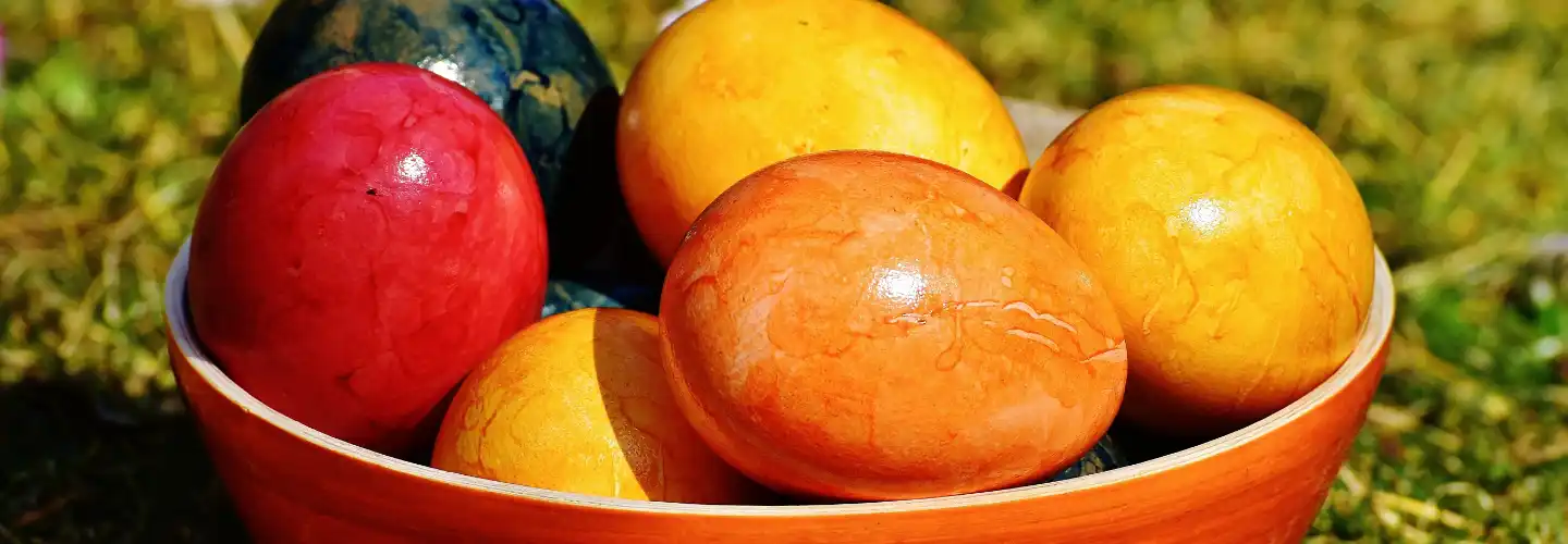 A selection of brightly coloured Easter eggs in a bowl